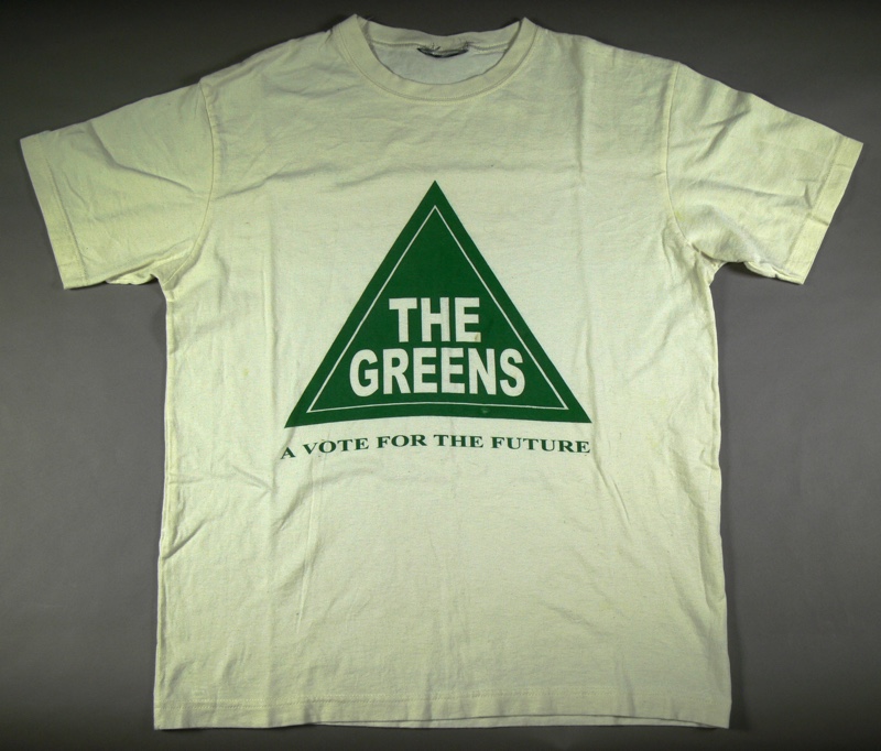 A white t-shirt with a triangle Greens logo and the words 'a vote for the future'. A white t-shirt with a triangle Greens logo and the words 'a vote for the future'.