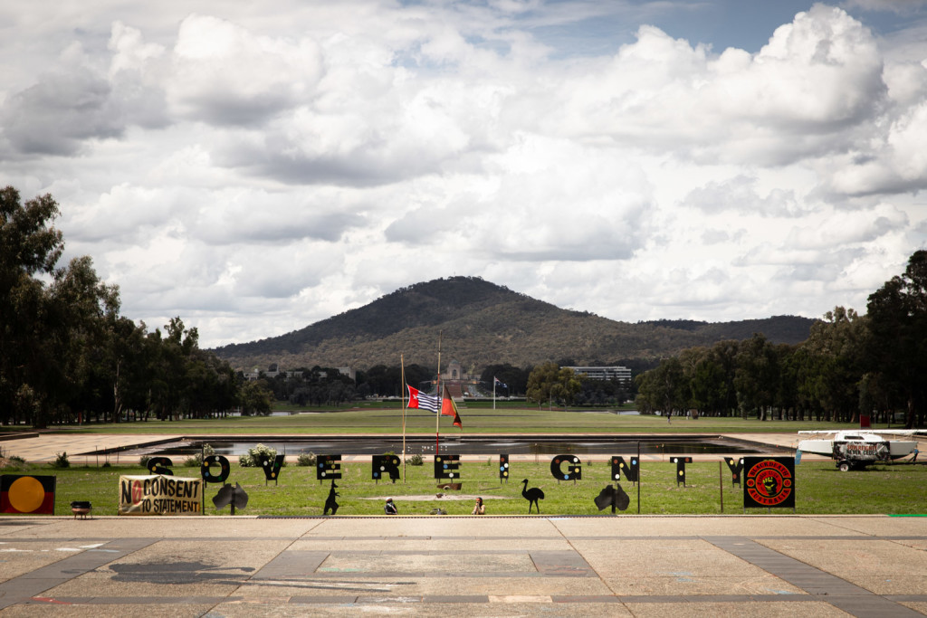 The site of the Aboriginal Tent Embassy on the lawns outside Old Parliament House. Black letters spell out the word 'Sovereignty' on a green lawn. The site of the Aboriginal Tent Embassy on the lawns outside Old Parliament House. Black letters spell out the word 'Sovereignty' on a green lawn.