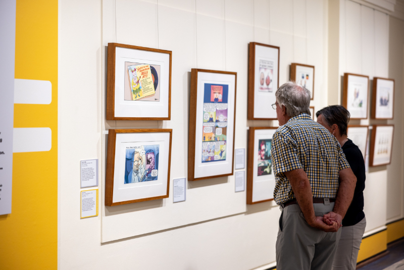 Visitors looking at the framed cartoons on the walls Visitors looking at the framed cartoons on the walls