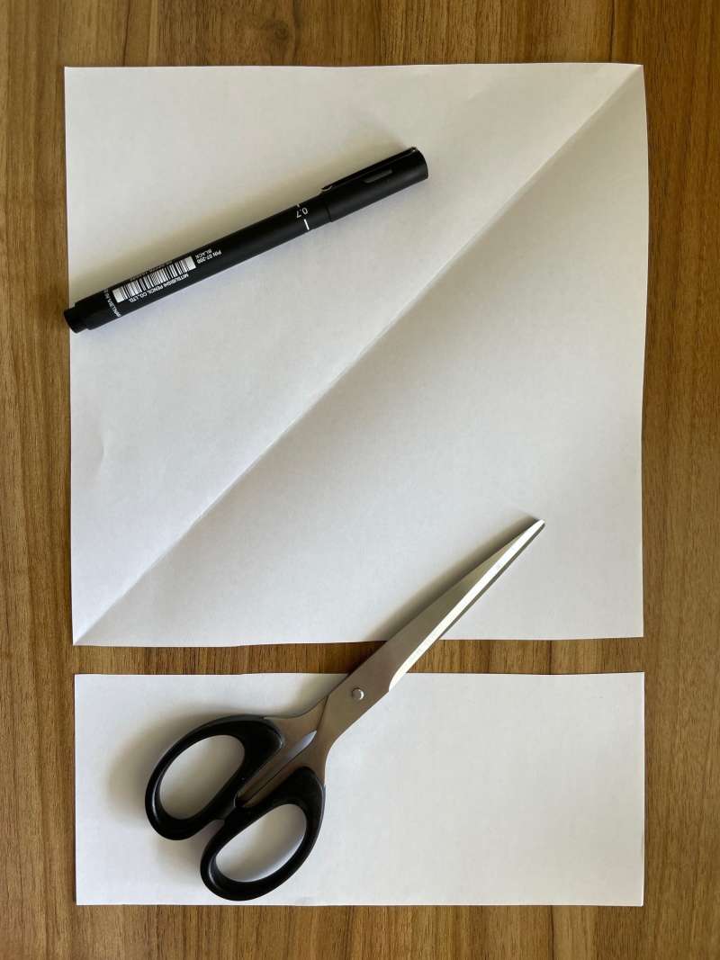 A rectangular piece of paper with the bottom cut off to make a square piece of paper. A rectangular piece of paper with the bottom cut off to make a square piece of paper.