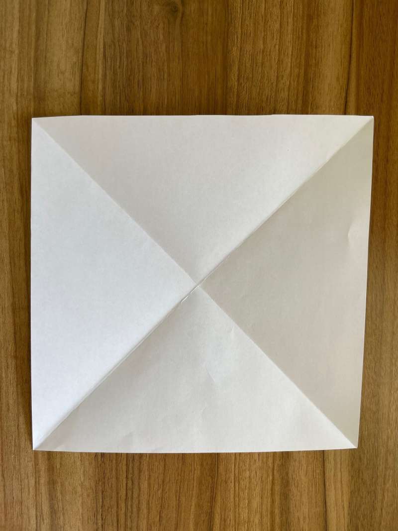 A square piece of paper with diagonal creases. A square piece of paper with diagonal creases.