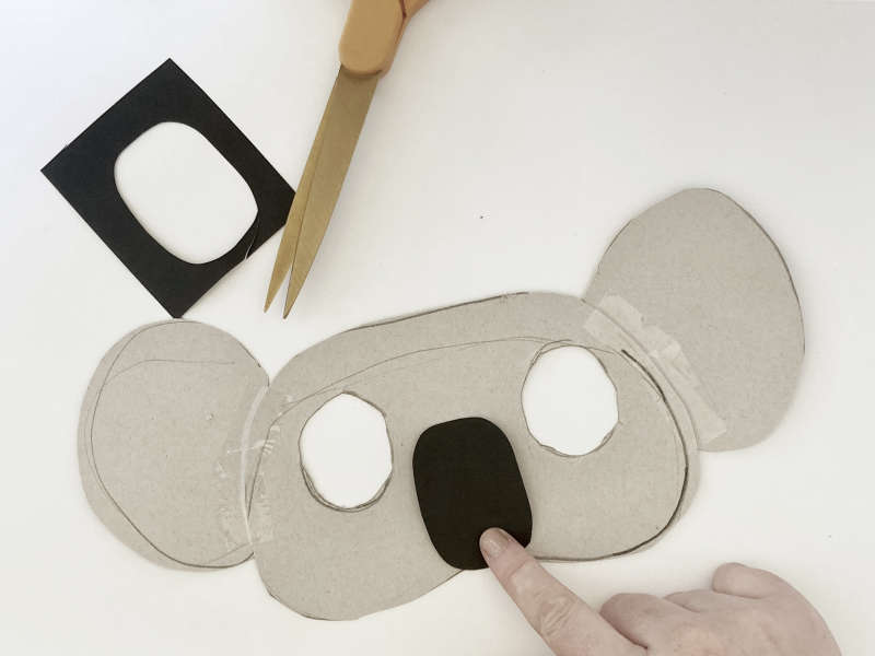 A koala mask with two eye holes cut out and a black nose. A koala mask with two eye holes cut out and a black nose.