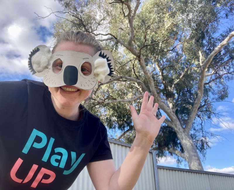 A PlayUp facilitator wears a koala mask outside. A PlayUp facilitator wears a koala mask outside.