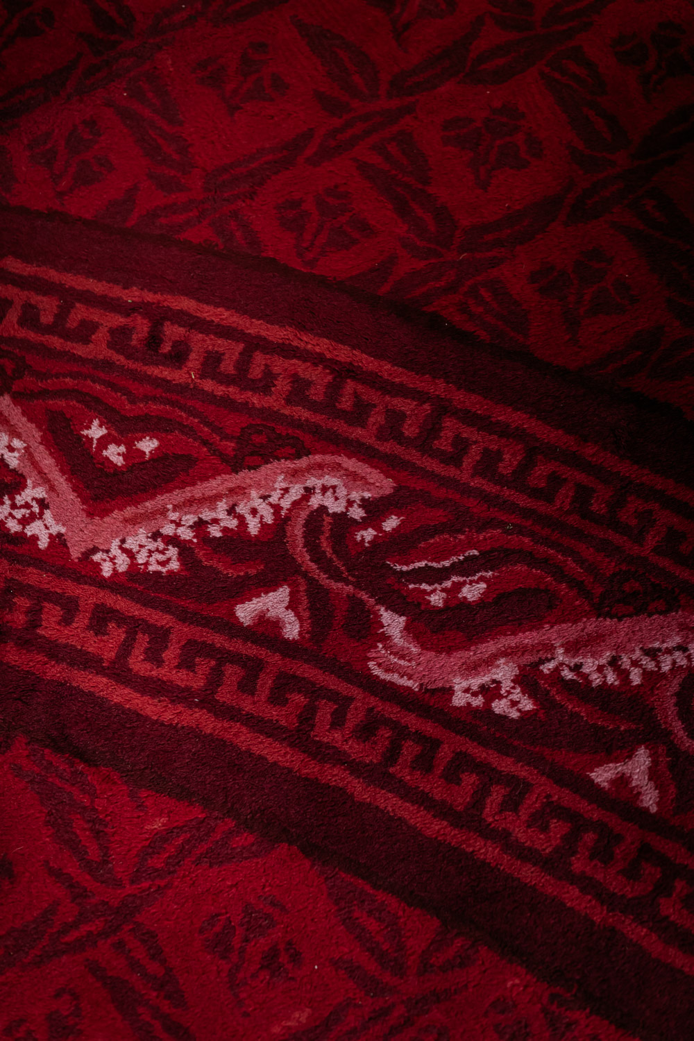 A close up of red carpet with an ornate pattern.