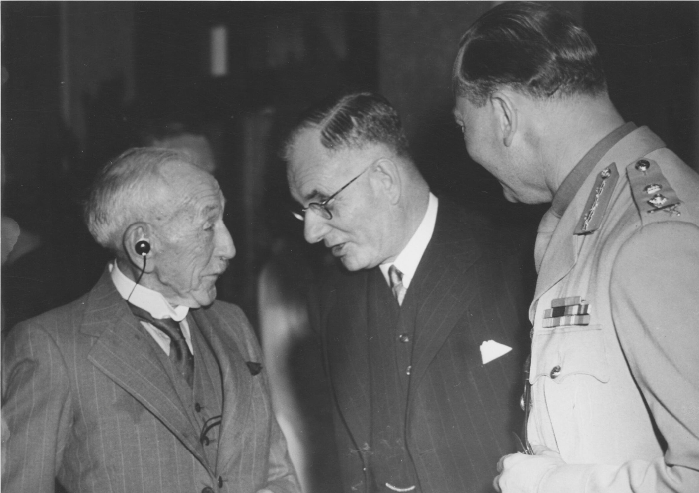 Billy Hughes wearing his 'accousticon', in conversation with John Curtin and the Duke of Gloucester. Billy Hughes wearing his 'accousticon', in conversation with John Curtin and the Duke of Gloucester.