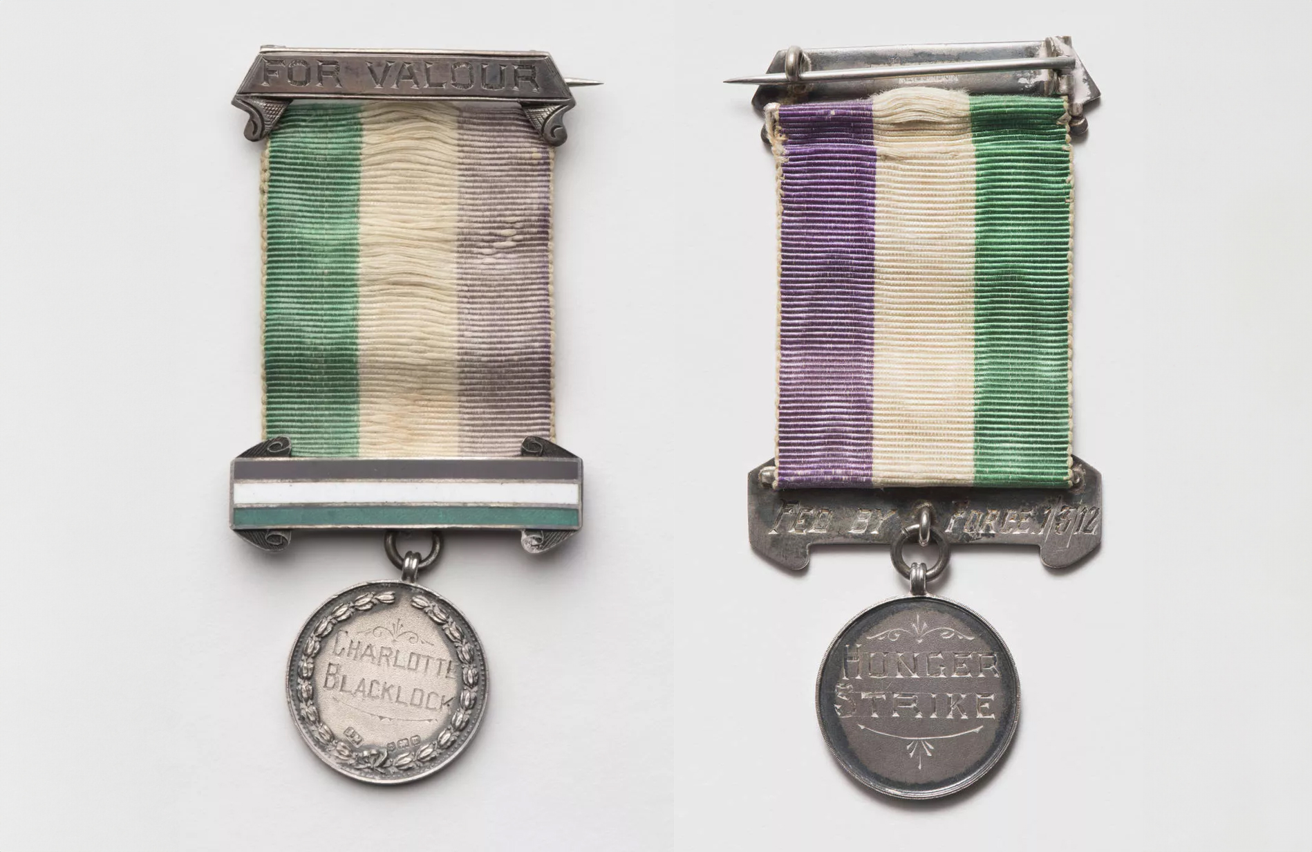 A round medal attached to a green, white and purple ribbon, etched onto the front the words 'For Valour' and 'Charlotte Blacklock', on the back 'Fed by force 1/3/12' and 'hunger strike'. A round medal attached to a green, white and purple ribbon, etched onto the front the words 'For Valour' and 'Charlotte Blacklock', on the back 'Fed by force 1/3/12' and 'hunger strike'.