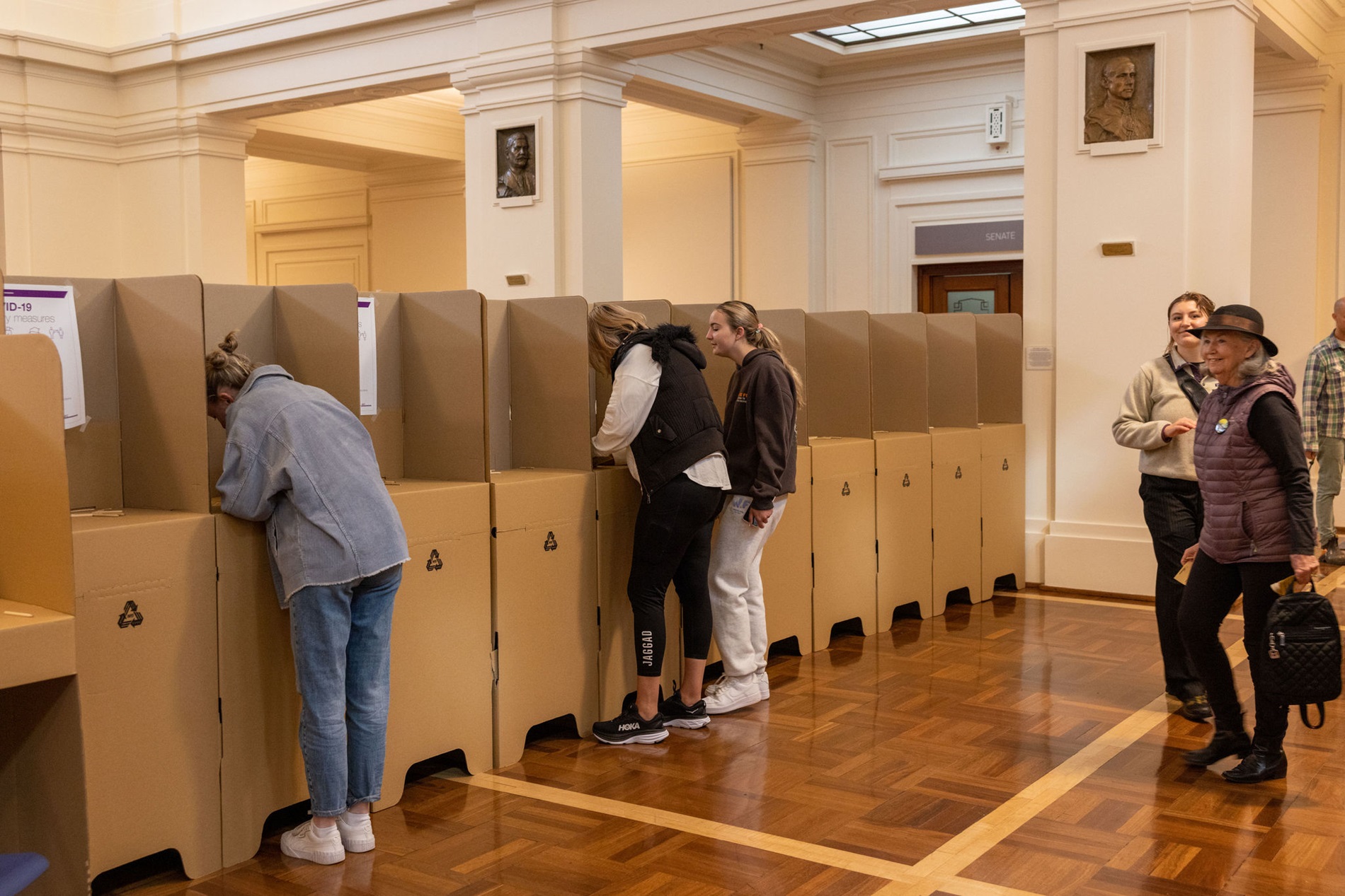 Three women standing at cardboard polling booths in King's Hall. Three women standing at cardboard polling booths in King's Hall.