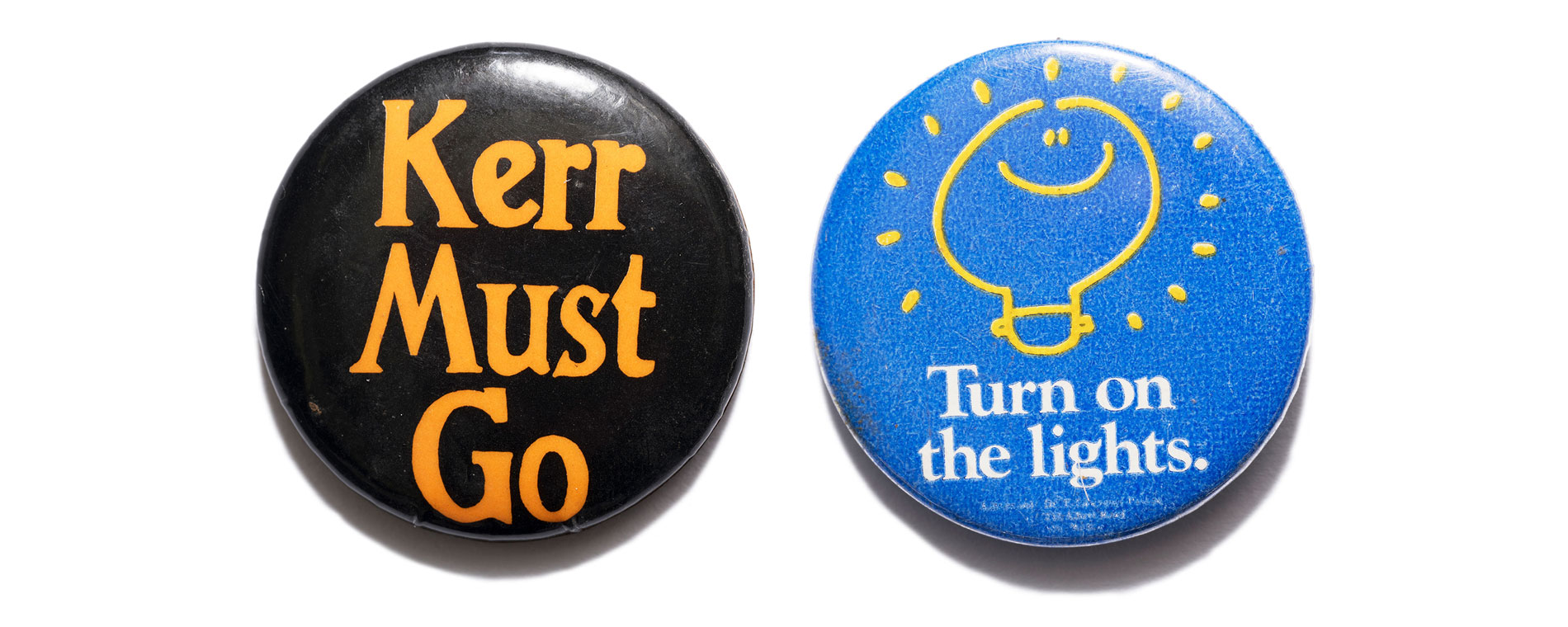 A black badge with 'Kerr must go' text in orange and a blue badge with 'Turn on the lights' text in white.
