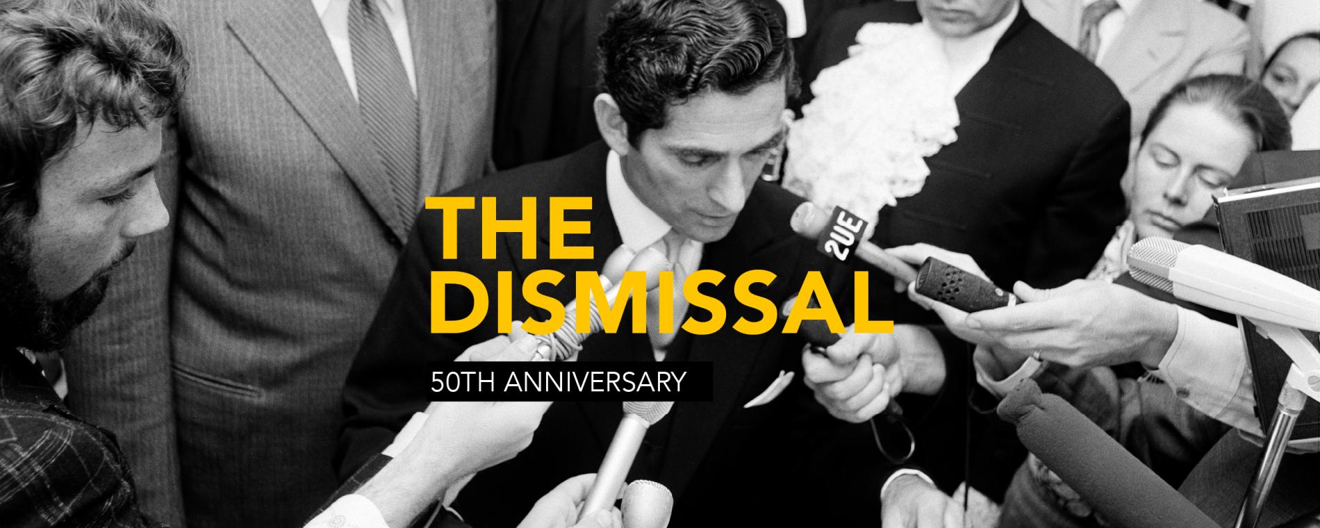 Many hands hold microphones toward David Smith's face as he reads the proclamation dissolving parliament. The words 'The Dismissal 50th Anniversary' appear over the top of the image.
