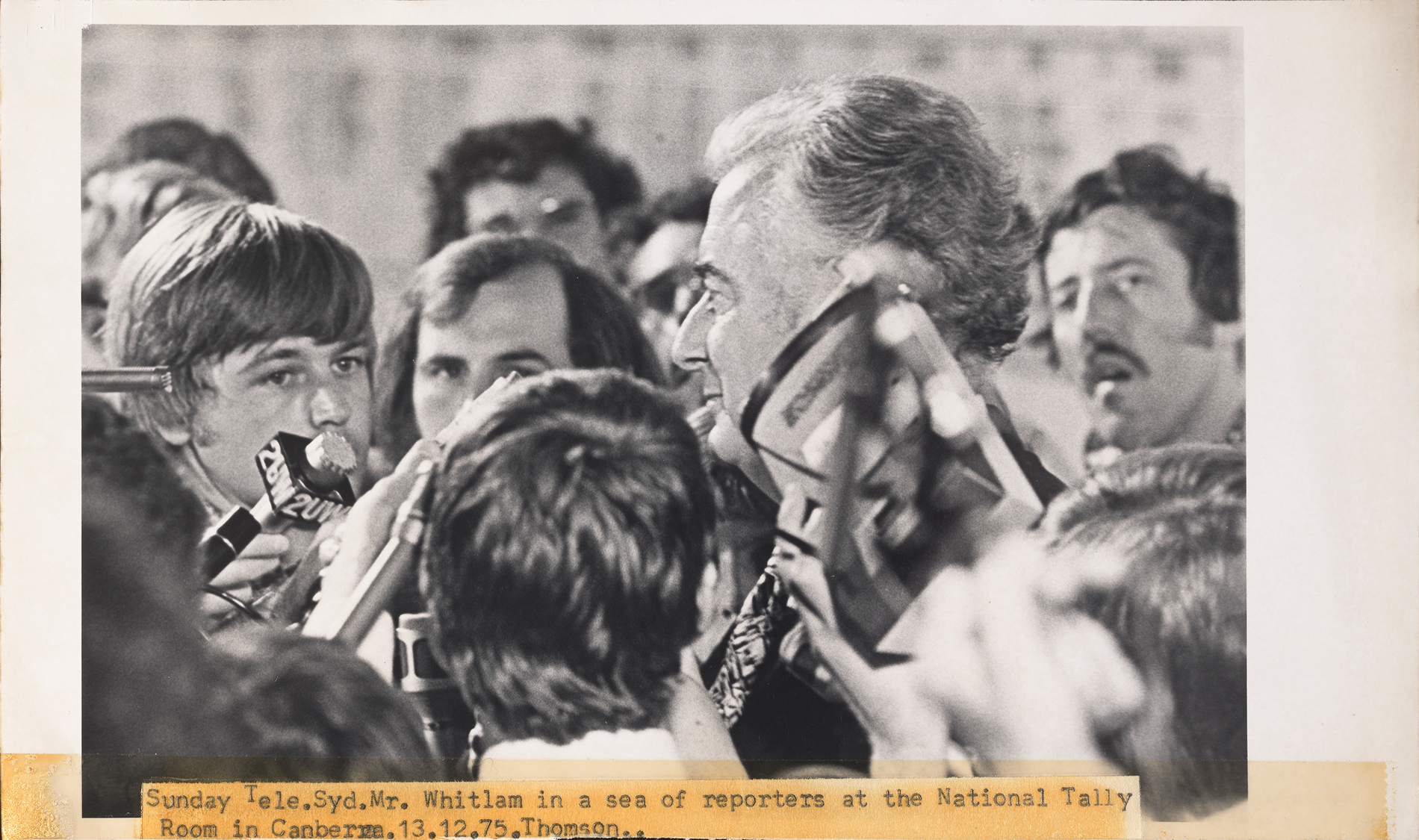 Gough Whitlam swarmed by reporters while visiting the National Tally Room one the night of the 1975 election, one month after he was dismissed as prime minister.