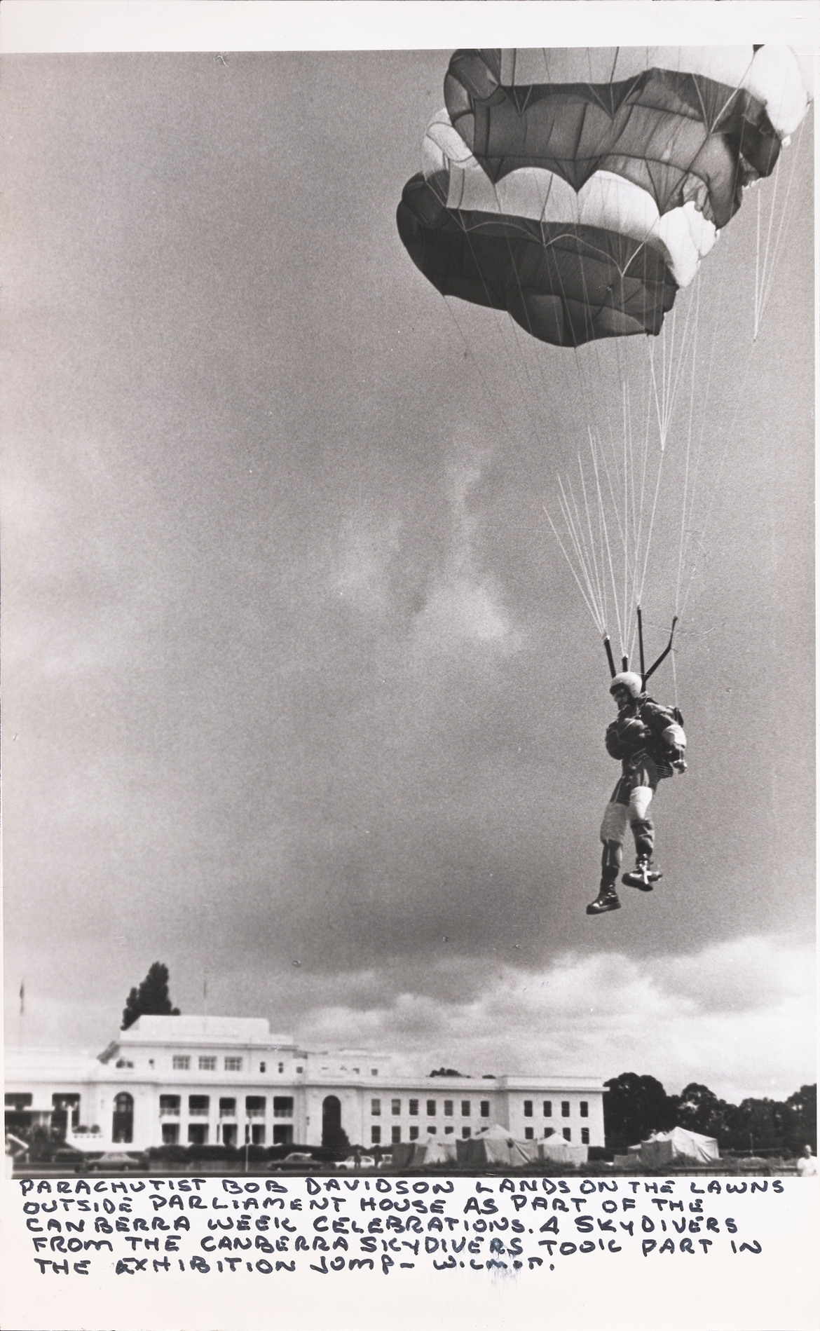 A parachutist landing on the lawns outside of Parliament house as part of the Canberra Week celebrations.