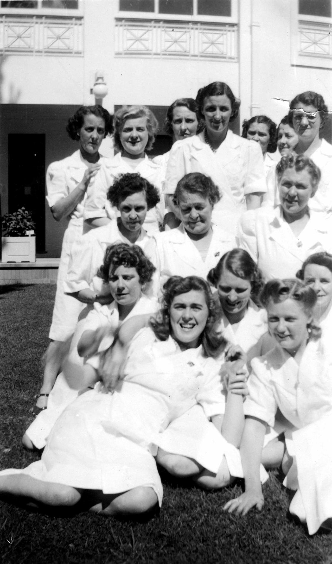 A black and white image of kitchen staff in a courtyard at Old Parliament House wearing a white uniform.