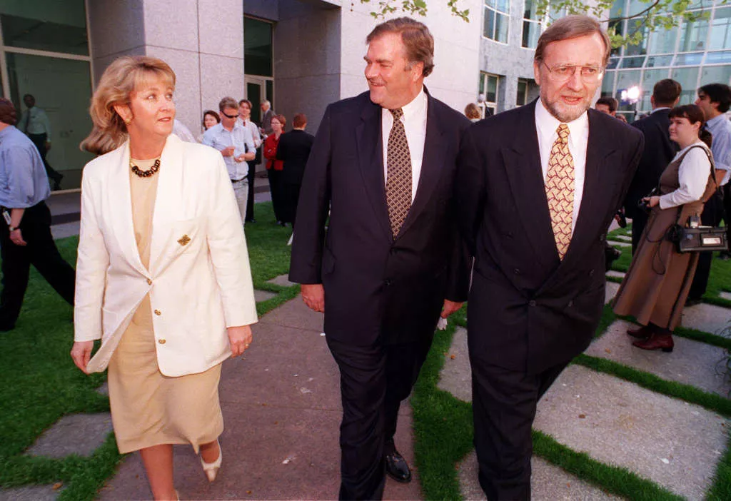 Cheryl Kernot, walks through a courtyard, exchanging a glance with Kim Beazley, Gareth Evans walking alongside them. Cheryl Kernot, walks through a courtyard, exchanging a glance with Kim Beazley, Gareth Evans walking alongside them.