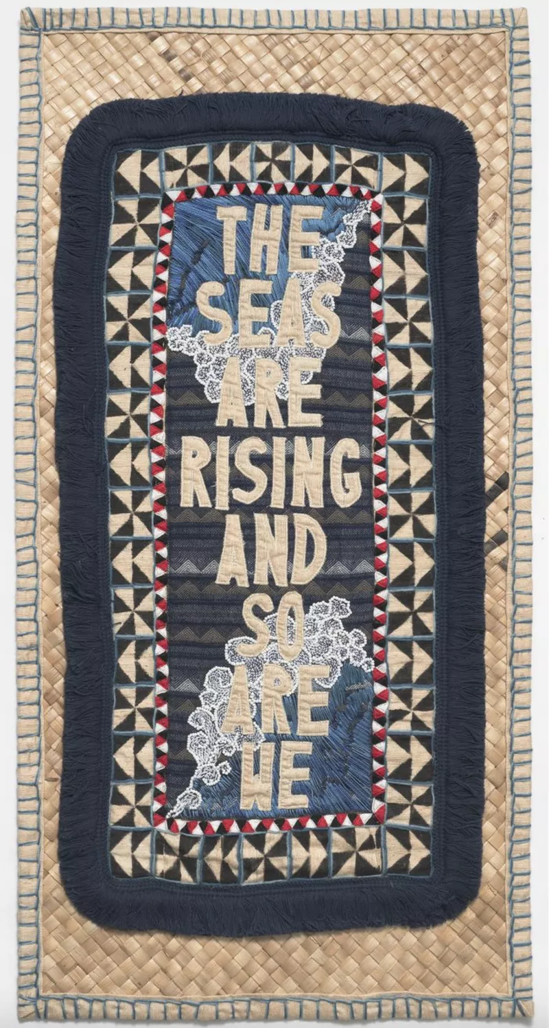 Blue, beige and black tapestry that contains the message 'The seas are rising and so are we'. Blue, beige and black tapestry that contains the message 'The seas are rising and so are we'.