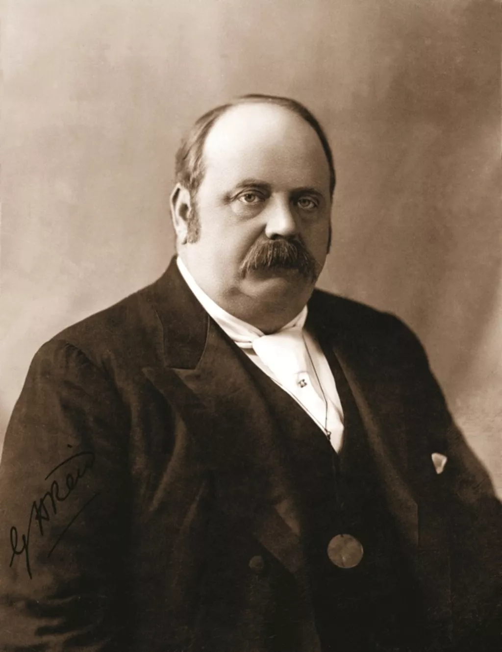 George Reid, wearing a dark three-piece formal suit and a white tie. George Reid, wearing a dark three-piece formal suit and a white tie.