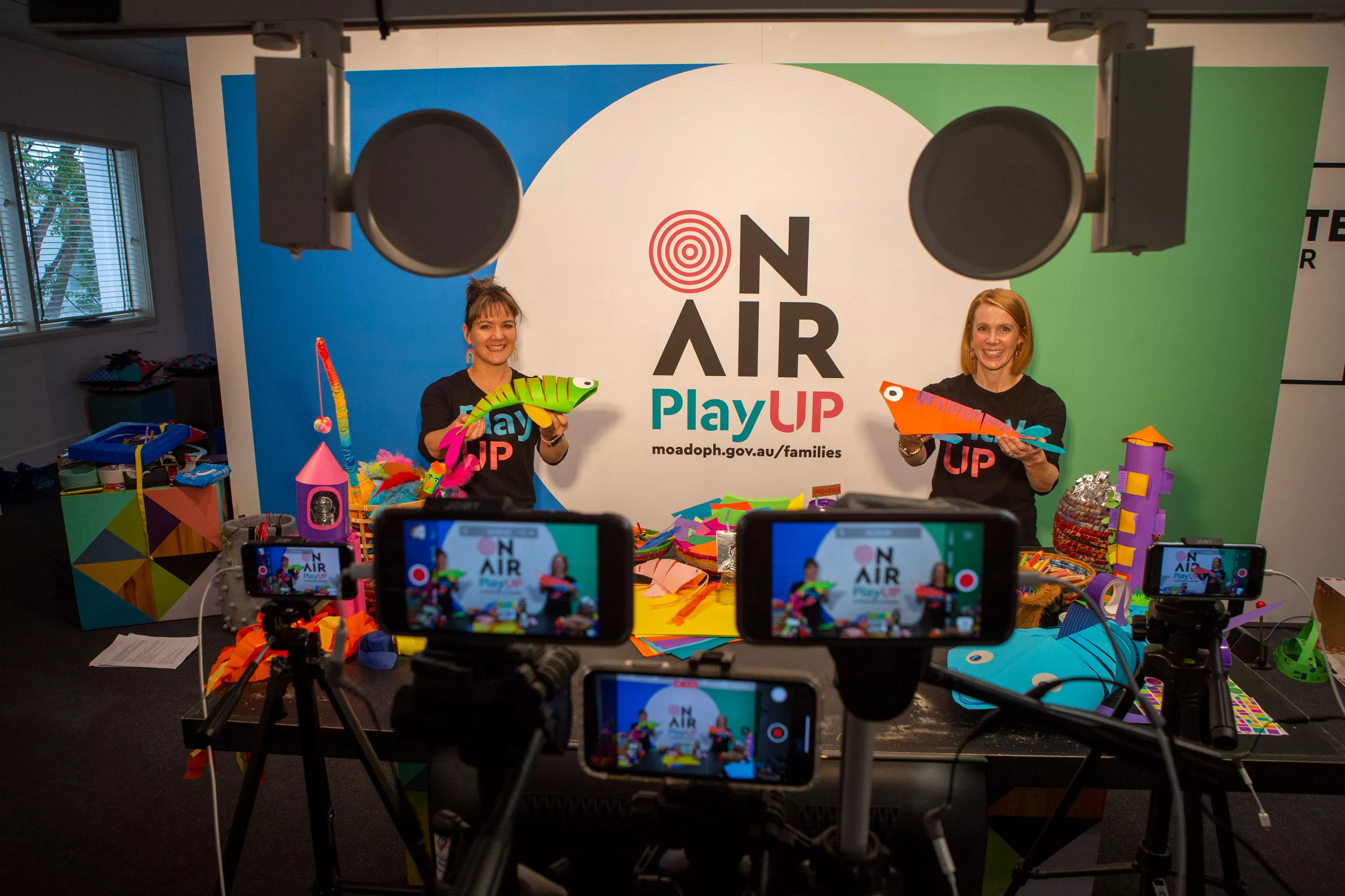 Two presenters stand in front of cameras on a set presenting a children's show. Two presenters stand in front of cameras on a set presenting a children's show.