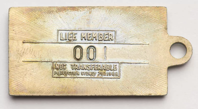 Photogfraph of the back of a metal tag labled "life member". Photogfraph of the back of a metal tag labled "life member".