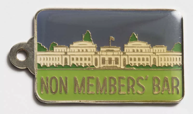 Photograph of a metal tag with an enameled illustration of Provisional Parliament House and the label "Non member's bar" Photograph of a metal tag with an enameled illustration of Provisional Parliament House and the label "Non member's bar"