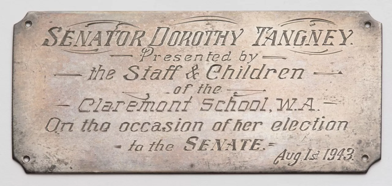 Photograph of a metal plaque labled "SENATOR DORTHOY TANGNEY. Presented by the Staff and Children of the Claremont School, W.A. On the occasion of her election to the Senate. Aug 1st 1943." Photograph of a metal plaque labled "SENATOR DORTHOY TANGNEY. Presented by the Staff and Children of the Claremont School, W.A. On the occasion of her election to the Senate. Aug 1st 1943."