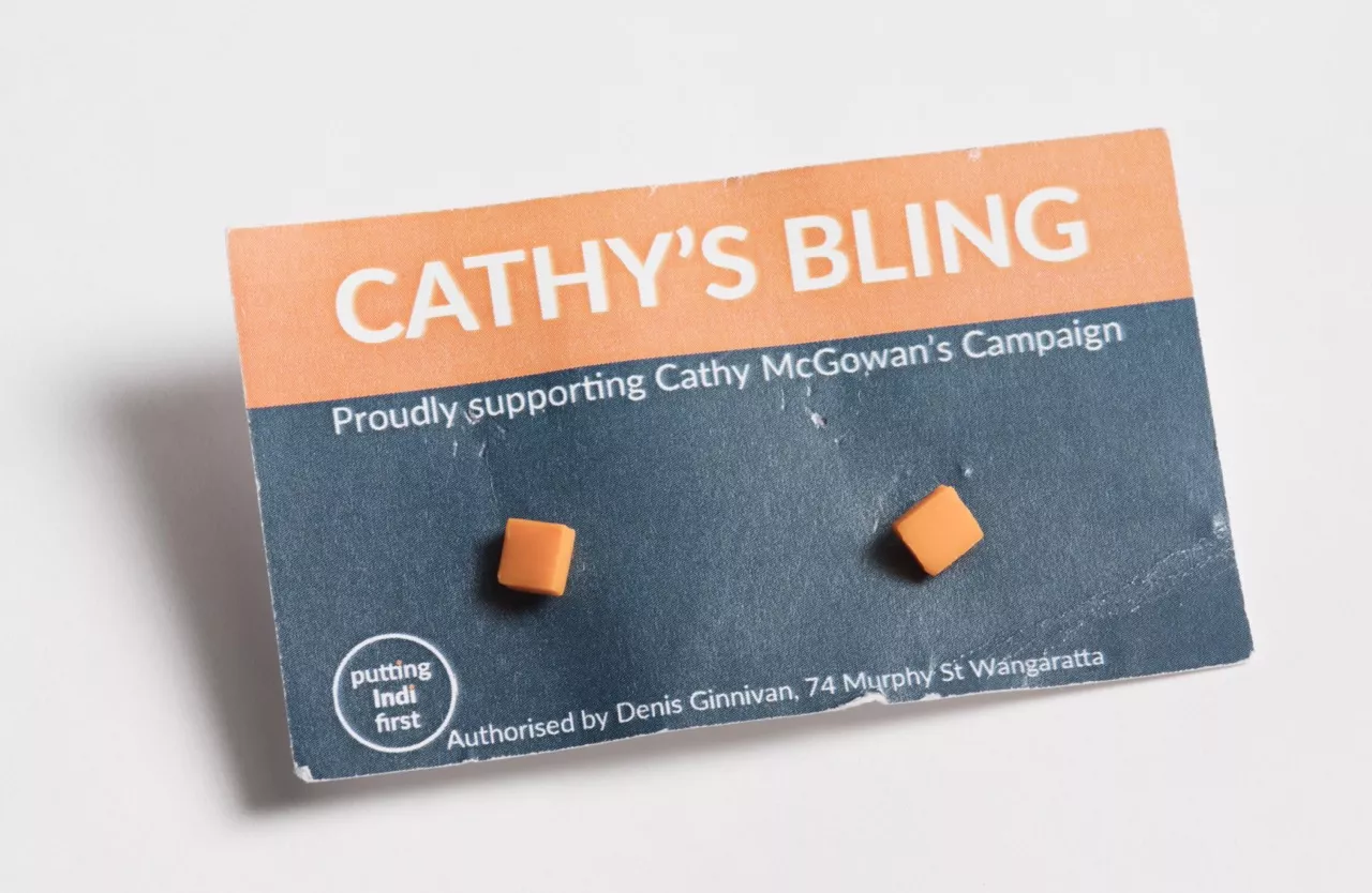 Photograph of two orange square earrings attached to a card with the lablel "CATHY'S BLING - Proudly supporting Cathy McGowan's Campaign" Photograph of two orange square earrings attached to a card with the lablel "CATHY'S BLING - Proudly supporting Cathy McGowan's Campaign"