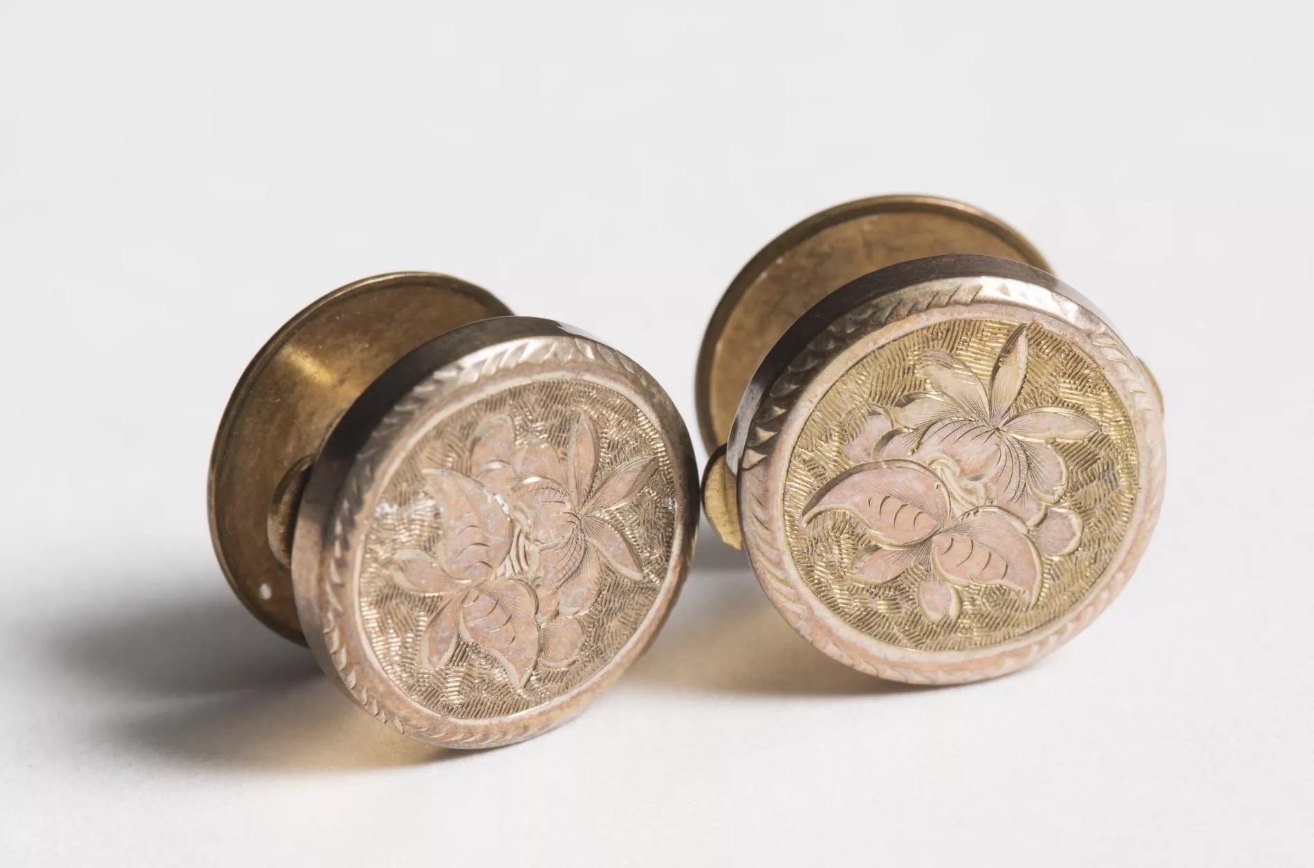 Photograph of two brass coloured cufflinks Photograph of two brass coloured cufflinks