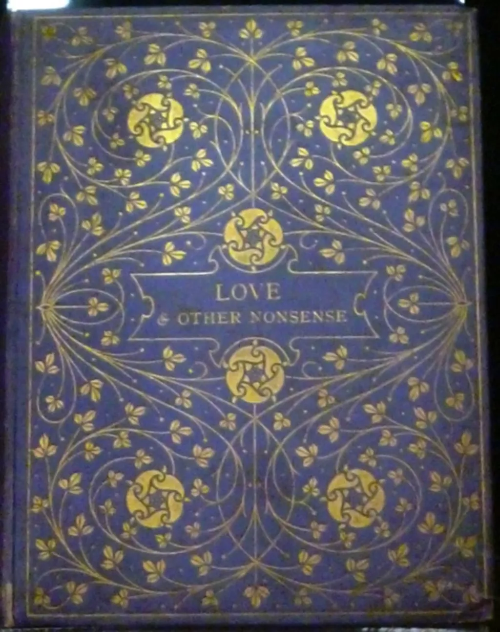 A blue book cover with the title 'Love & other nonsense' and an ornate floral design embossed in gold. A blue book cover with the title 'Love & other nonsense' and an ornate floral design embossed in gold.