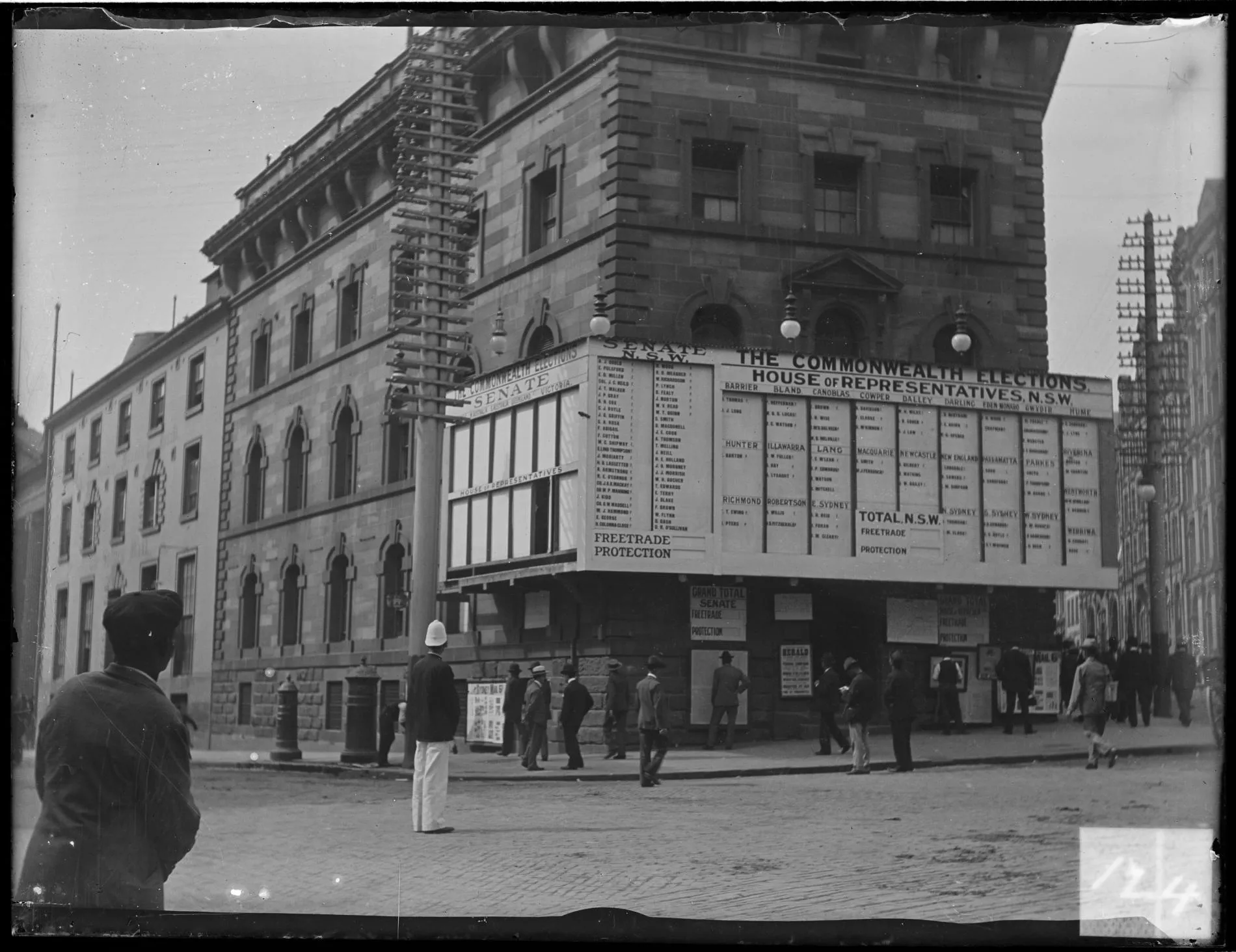 People stand on the street in Sydney looking at a building displaying a giant tally board showing the results of the 1901 federal election. People stand on the street in Sydney looking at a building displaying a giant tally board showing the results of the 1901 federal election.