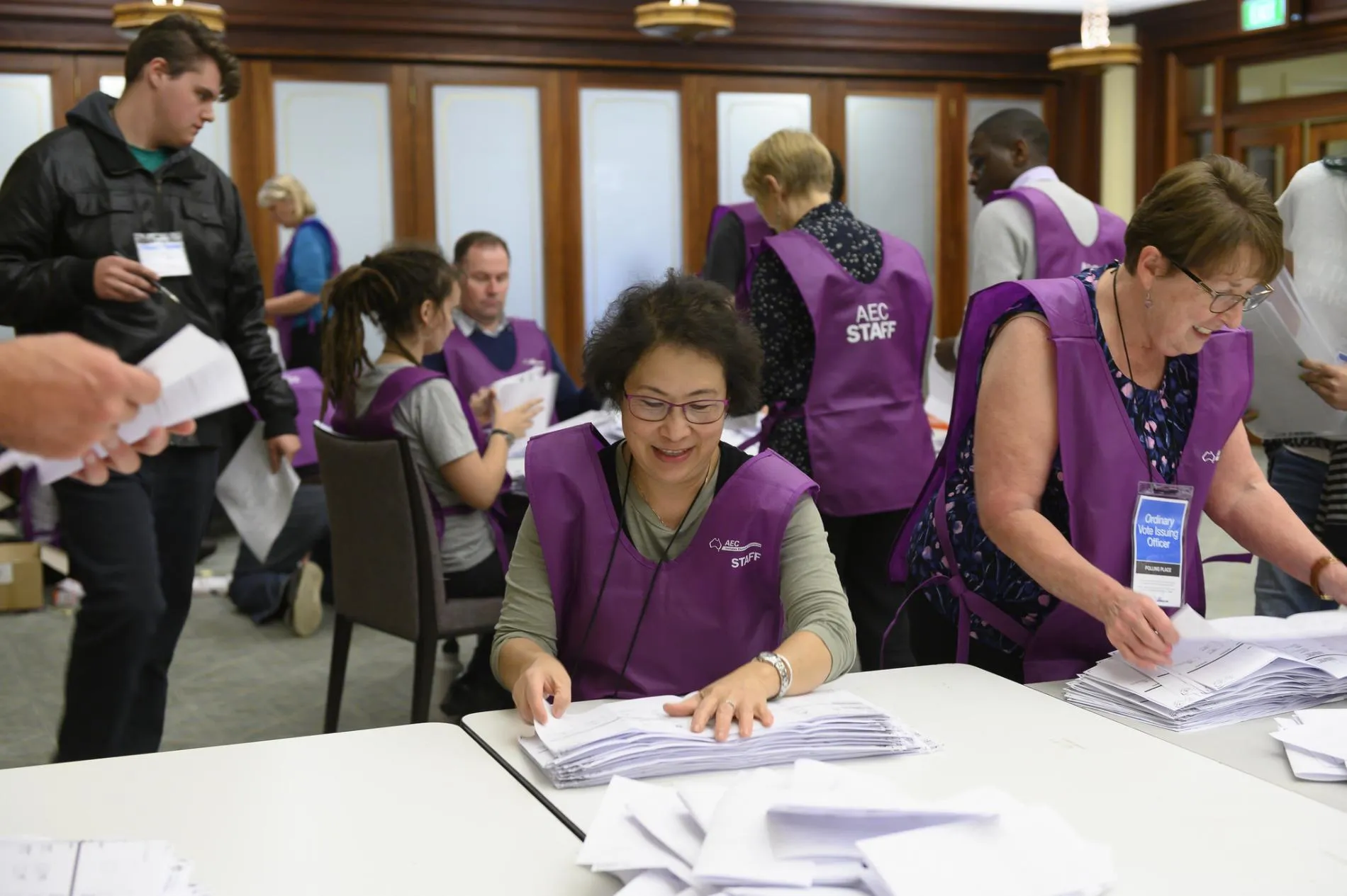 AEC staff wearing purple vests count white ballot papers in Old Parliament House. AEC staff wearing purple vests count white ballot papers in Old Parliament House.