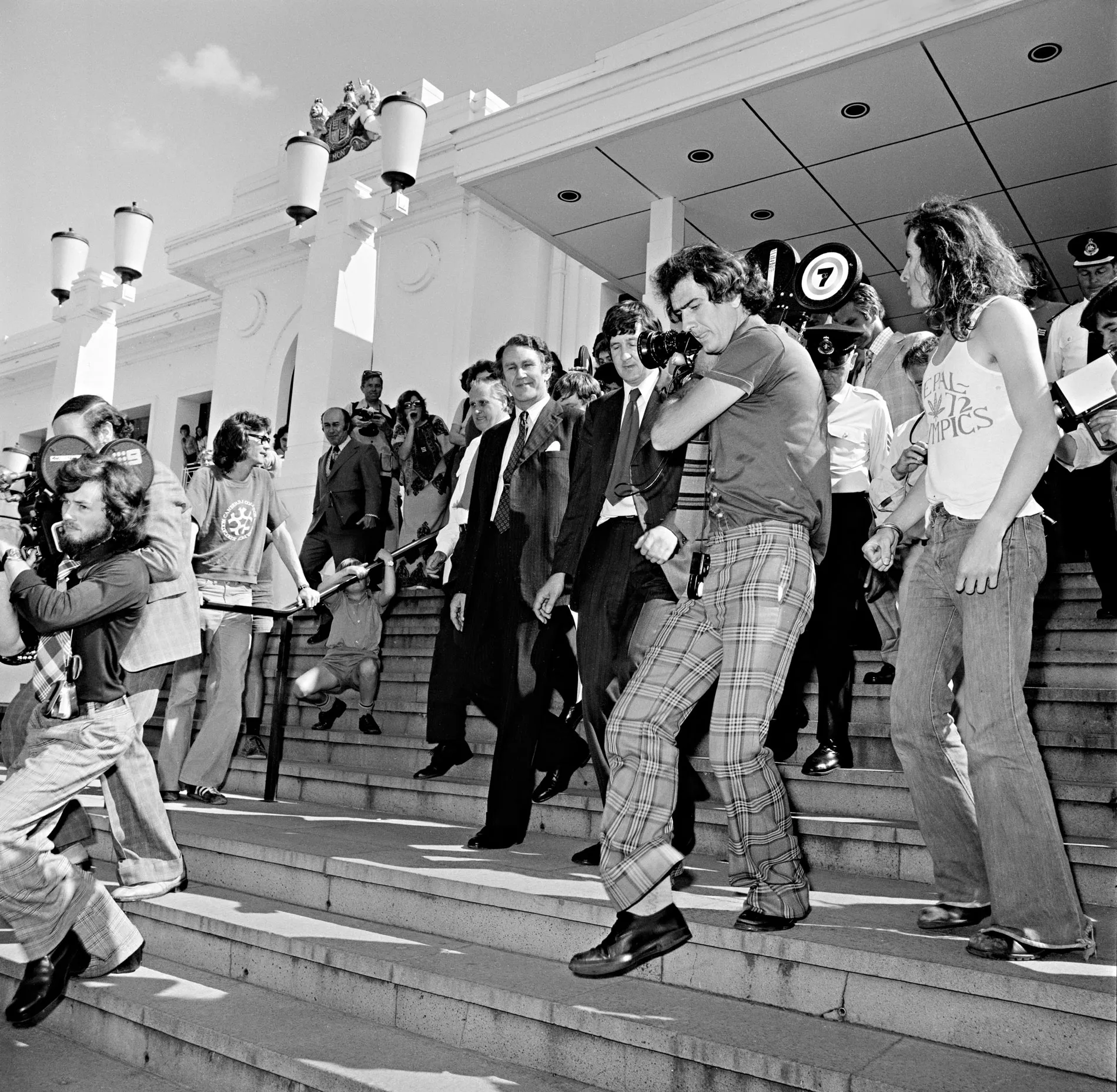 Malcolm Fraser surrounded by press and crowds on the steps of Parliament House.