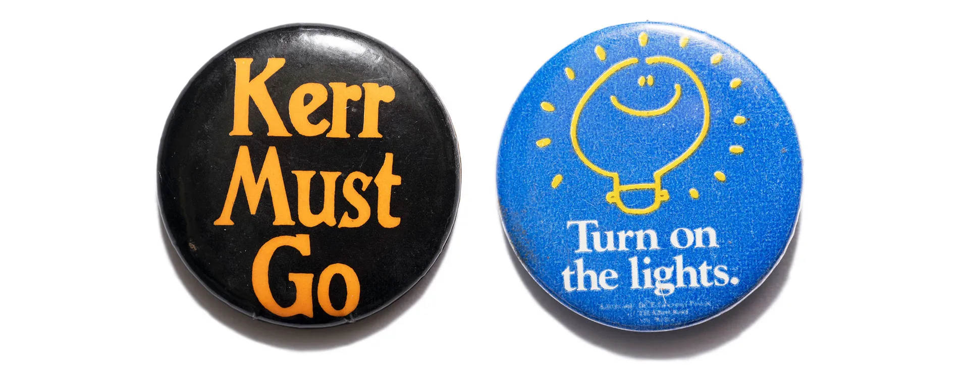 A black badge with 'Kerr must go' text in orange and a blue badge with 'Turn on the lights' text in white.