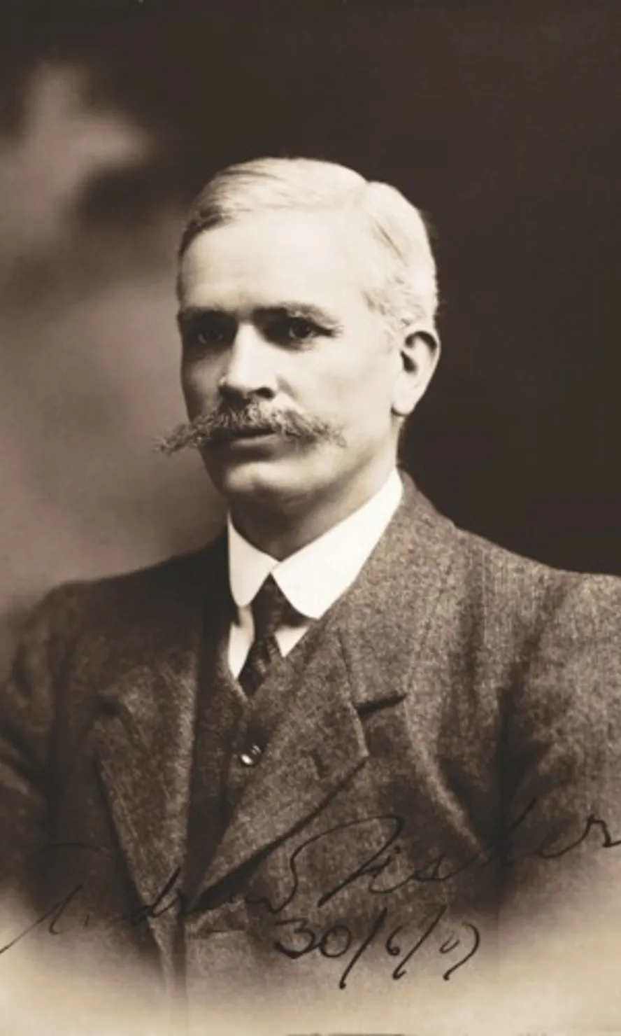 Black and white portrait photograph of Andrew Fisher, wearing a three-piece suit and sporting a long moustache. Black and white portrait photograph of Andrew Fisher, wearing a three-piece suit and sporting a long moustache.