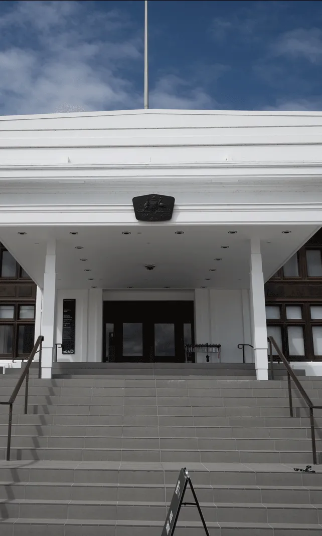 A large staircase leading up a large white building with two banners on either side. One reads 'Democracy DNA' and the other reads 'Behind the Lines'. A large staircase leading up a large white building with two banners on either side. One reads 'Democracy DNA' and the other reads 'Behind the Lines'.