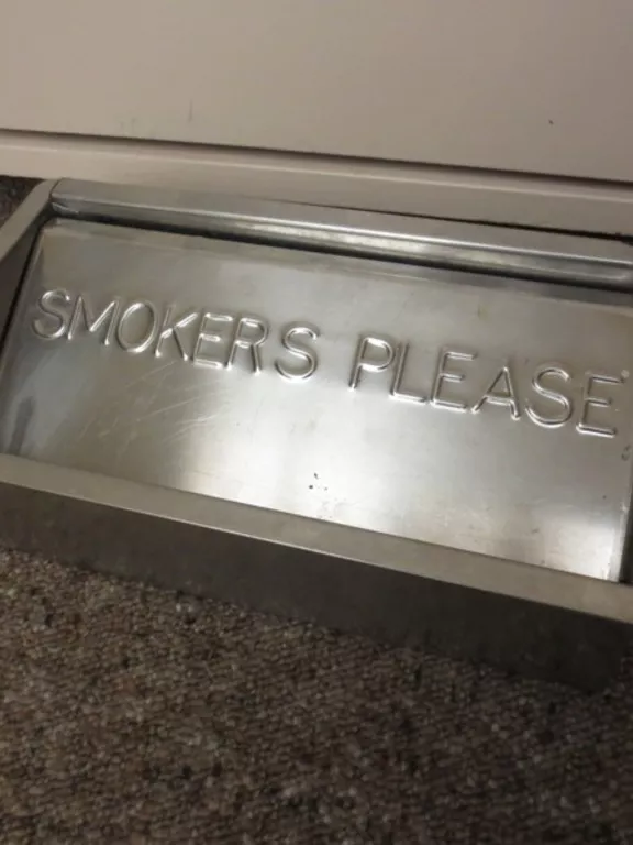 Floor ashtray made from metal A metal floor ashtray with the inscription 'SMOKERS PLEASE'.