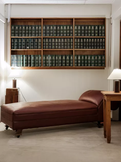 A chaise sofa with side table and bookshelf built into the wall A chaise sofa with side table and bookshelf built into the wall