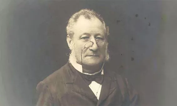 A man, William Groom, wearing a dark suit, black bow tie and pince-nez glasses. A man, William Groom, wearing a dark suit, black bow tie and pince-nez glasses.