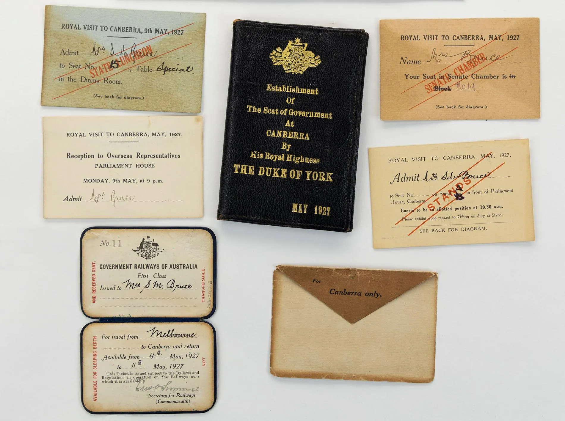 A black leather wallet with the Australian Coat of Arms and 'Establishment of the seat of Government at Canberra by His Royal Highness The Duke of York May 1927' embossed in gold, an envelope, first class railway ticket from Melbourne to Canberra for Mrs Bruce for travel from 4th May to 11th May 1927, rectangular tickets to the State Luncheon, Senate Chamber, Stands and Reception at Parliament House. A black leather wallet with the Australian Coat of Arms and 'Establishment of the seat of Government at Canberra by His Royal Highness The Duke of York May 1927' embossed in gold, an envelope, first class railway ticket from Melbourne to Canberra for Mrs Bruce for travel from 4th May to 11th May 1927, rectangular tickets to the State Luncheon, Senate Chamber, Stands and Reception at Parliament House.