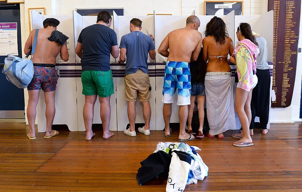 People wearing colourful boardshorts and beachwear stand at polling booths at a polling station in Sydney's Bondi Beach. People wearing colourful boardshorts and beachwear stand at polling booths at a polling station in Sydney's Bondi Beach.