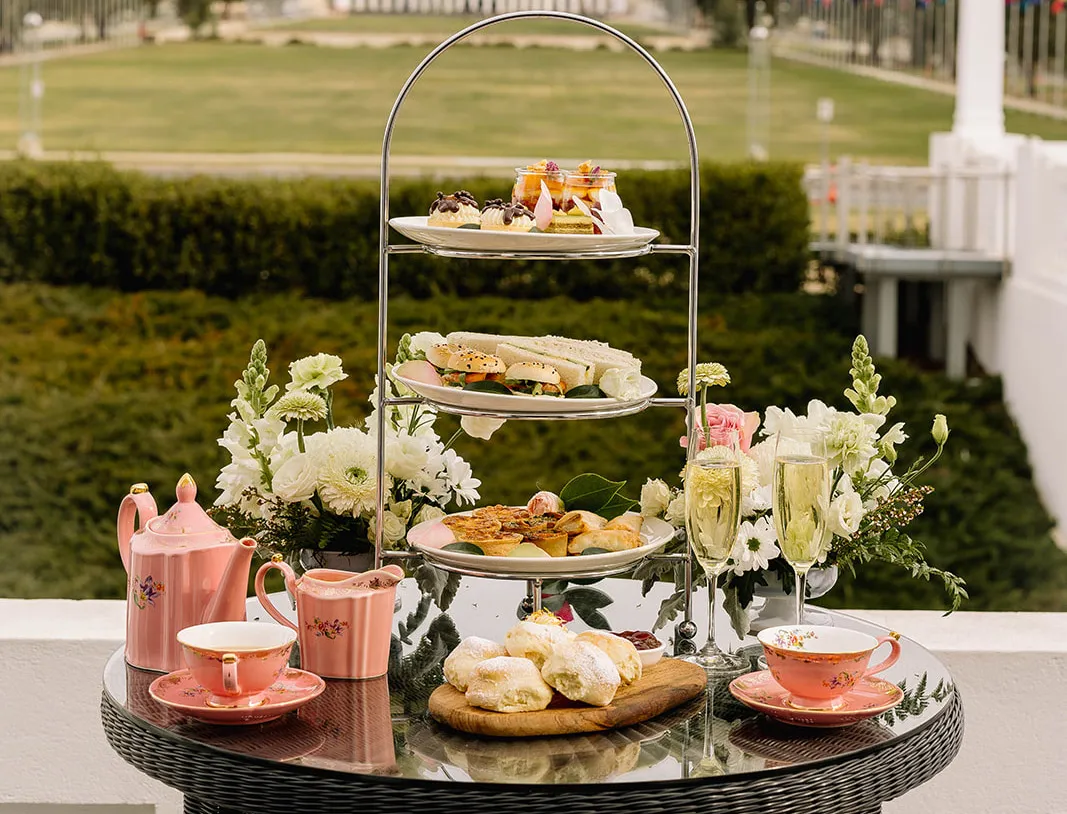 An outdoor table with high tea. An outdoor table with high tea.