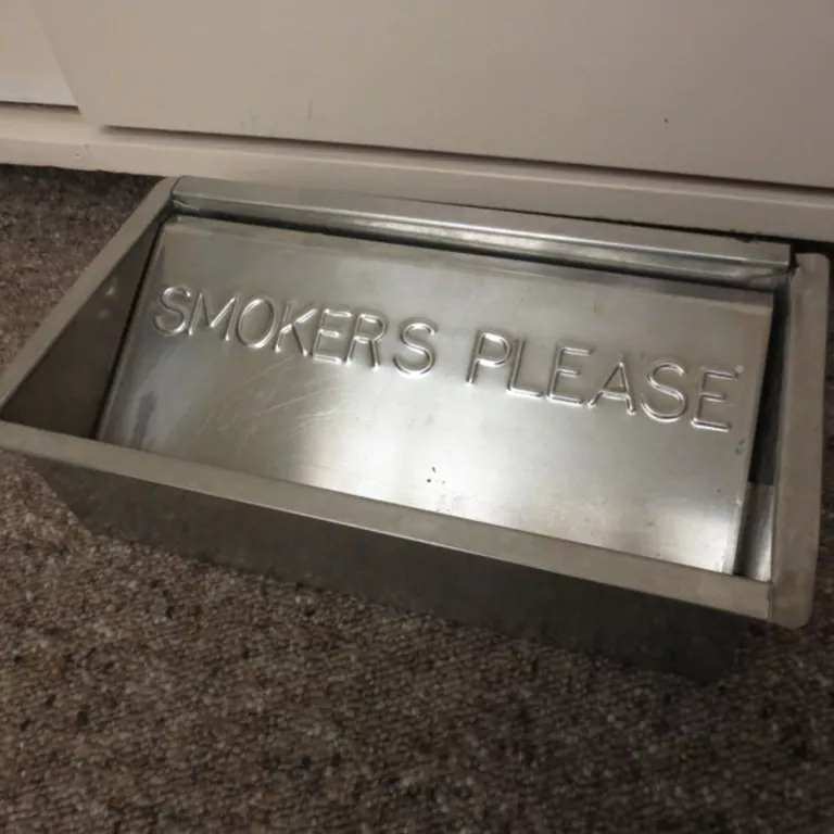 Floor ashtray made from metal A metal floor ashtray with the inscription 'SMOKERS PLEASE'.