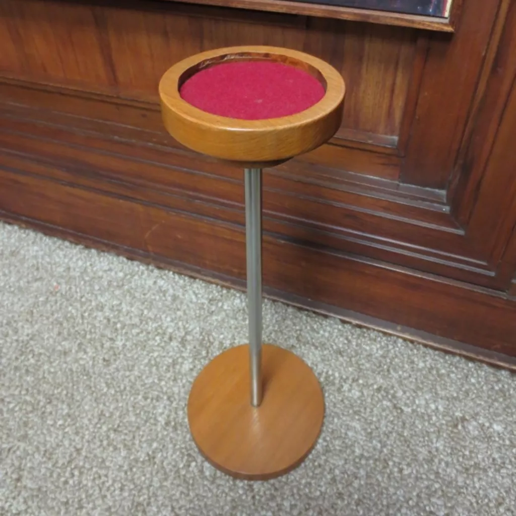 Wooden smokers stand for placing ashtrays on. A round wooden stand with a metal pole with wooden base.