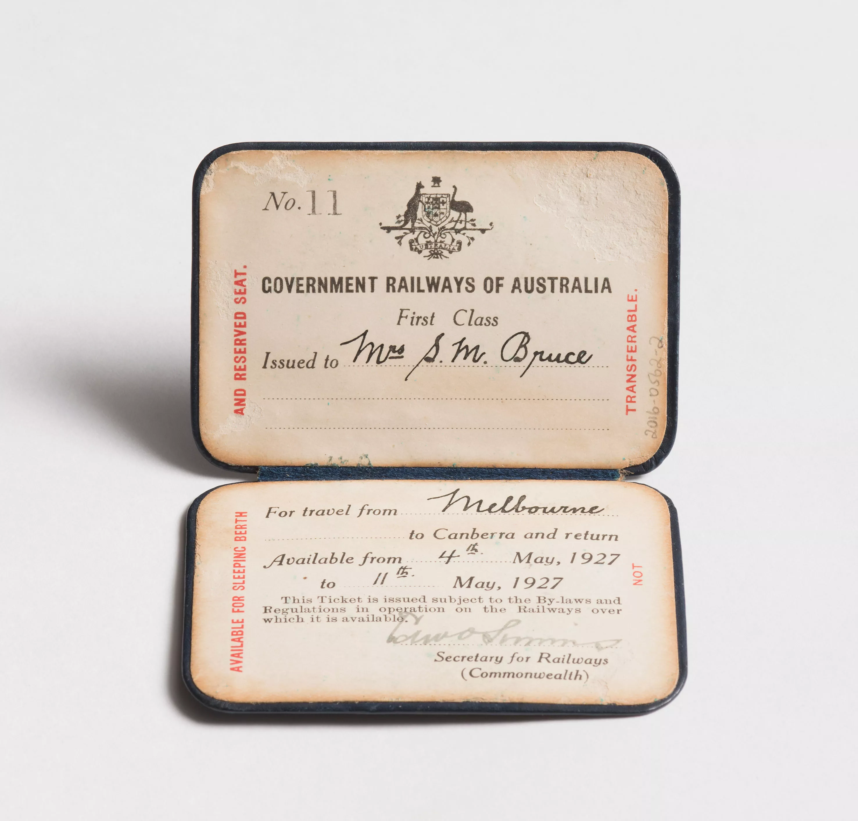 A faded paper railway ticket with cursive handwritten notes saying 'Mrs M Bruce for travel from Melbourne to Canberra' A faded paper railway ticket with cursive handwritten notes saying 'Mrs M Bruce for travel from Melbourne to Canberra'