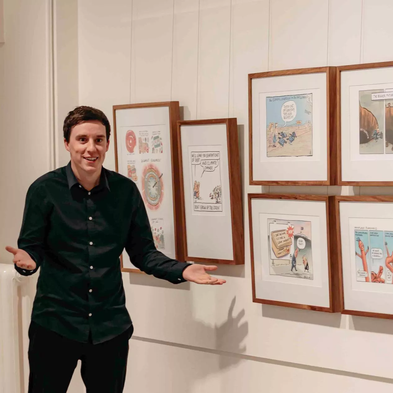 A MoAD educator stands in front of a wall of political cartoons. 