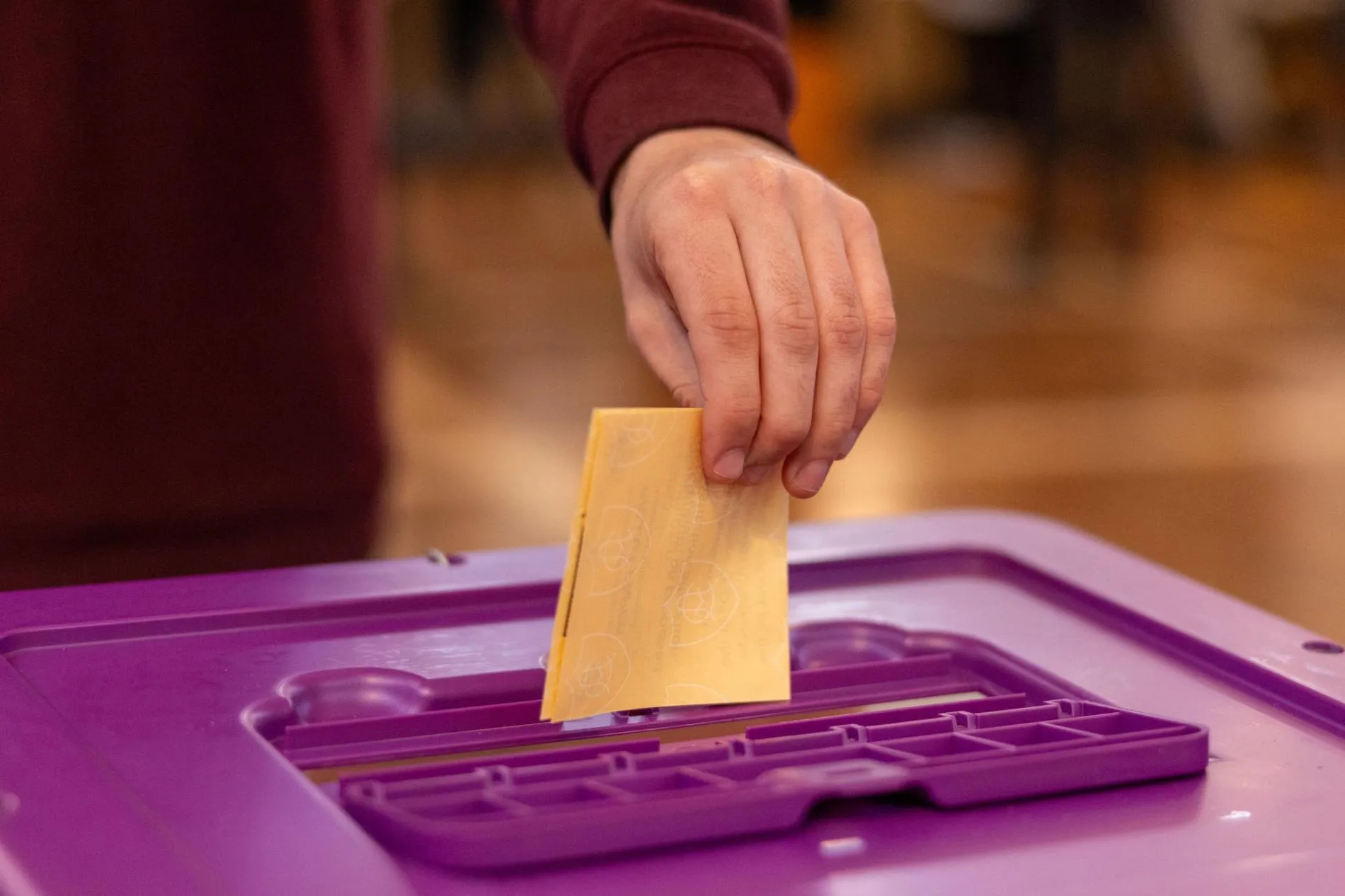 A voter puts a folded yellow ballot paper in a purple ballot box in Old Parliament House. A voter puts a folded yellow ballot paper in a purple ballot box in Old Parliament House.