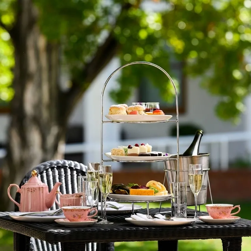 A high tea with cakes and scones on top of a table in the House of Representatives Courtyard at Old Parliament House.