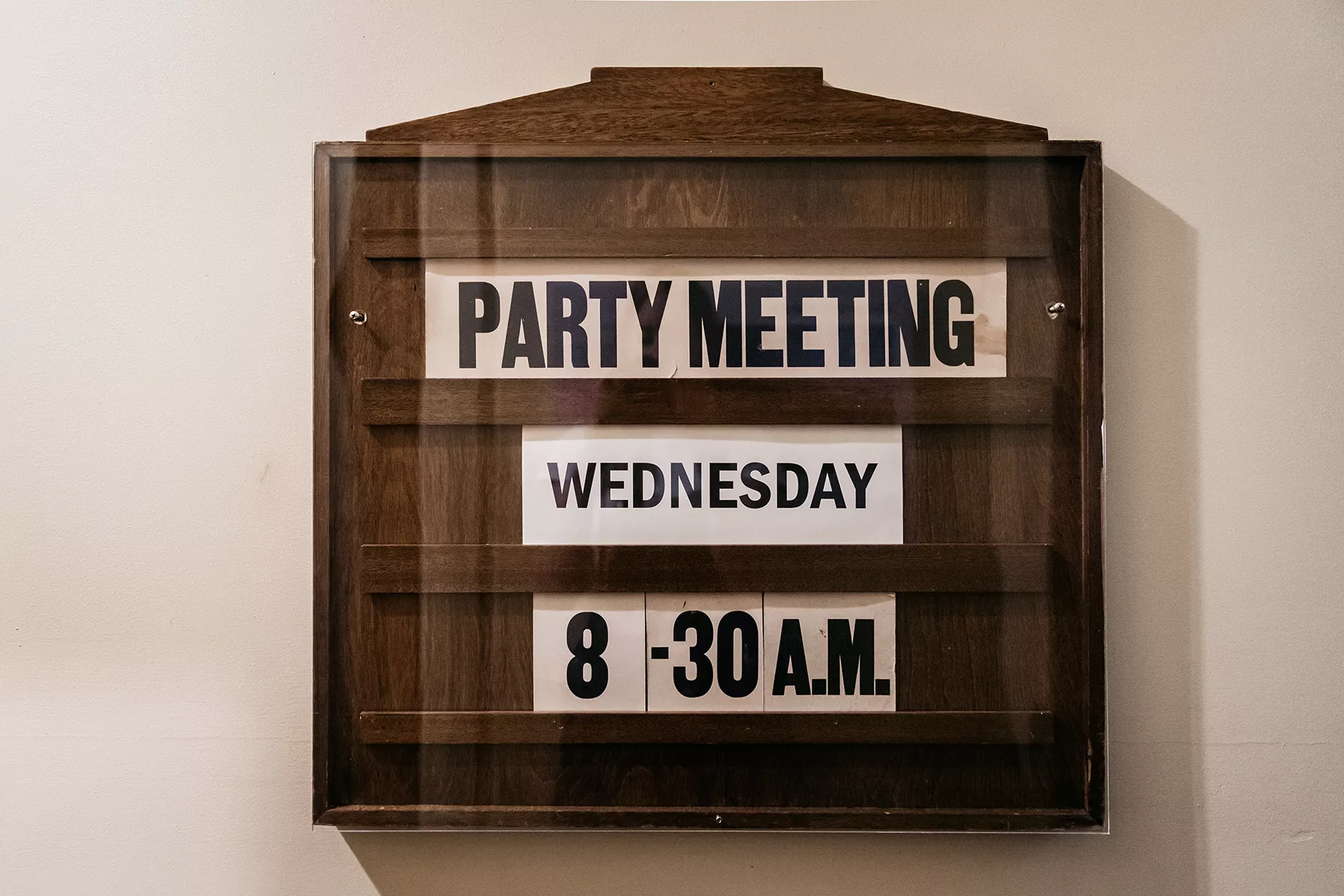 A wooden sign showing the date and time of the next party meeting A wooden sign showing the date and time of the next party meeting