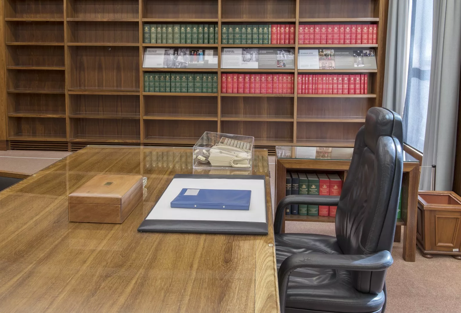 The honey-coloured black bean timber top of the prime minister's desk with a leather chair next to it. On the desktop there is a black leather blotter and a 1980s Telecom Commander telephone. The honey-coloured black bean timber top of the prime minister's desk with a leather chair next to it. On the desktop there is a black leather blotter and a 1980s Telecom Commander telephone.